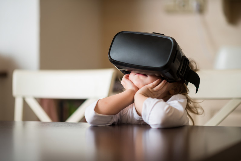 A little girl wearing a virtual reality headset
